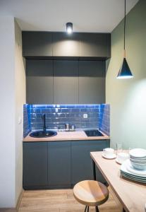 比托拉BEST APARTMENTS的厨房铺有蓝色瓷砖,配有水槽和桌子