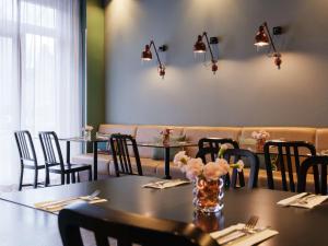 柏林柏林米特区阿迪纳公寓式酒店的用餐室配有桌椅和灯光