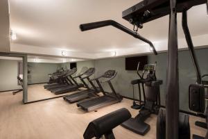 莱比锡莱比锡阿迪娜公寓酒店的一间健身房,里面设有一排跑步机