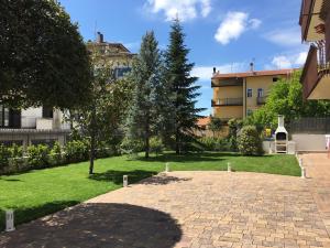 圣乔瓦尼·罗通多Villa Andalù Appartamenti的一座带砖砌人行道和建筑的花园