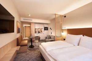 杜塞尔多夫Adina Apartment Hotel Dusseldorf的酒店客房设有一张大床和一个厨房。