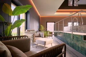 杜塞尔多夫Adina Apartment Hotel Dusseldorf的带沙发、椅子和植物的等候室