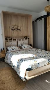 蒙特Superbe studio, vue lac, Spirou, rando, velo的一间卧室配有一张大床和木制床头板