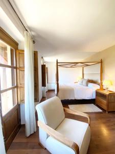 皮尔托贝加Hotel Rural Candela y Plata的一间卧室配有一张床、一张沙发和一把椅子
