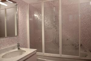 里瓦迪索尔托Alex's lake house的一间带玻璃淋浴间和水槽的浴室