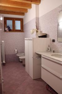 里瓦迪索尔托Alex's lake house的浴室设有2个卫生间、水槽和镜子