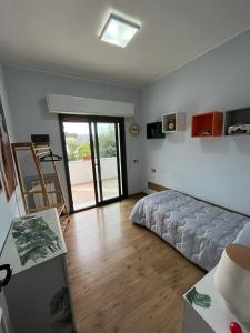 彼得拉桑塔Appartamento ORNELLO的一间卧室设有一张床和一个滑动玻璃门