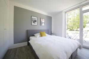 ElsauVARIAS Lifestyle Apartments的白色的卧室设有一张大床和一个窗户
