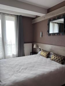 塞尔河畔维克圣克莱门特旅馆的卧室配有一张白色大床和镜子