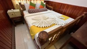 暹粒欧卡1别墅酒店的一张带白色床单和枕头的木床