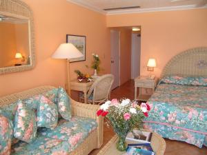 Mount Pleasant可可礁百慕达酒店的酒店客房,配有床、沙发和鲜花