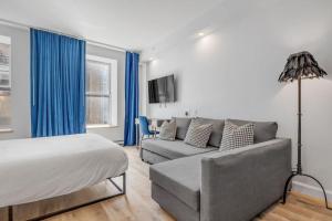 魁北克市Initial / Icone / Quebec+stat的一间卧室配有床、沙发和蓝色窗帘