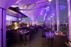 班加罗尔Citrus Hotel Cunningham的餐厅拥有紫色灯光和桌椅