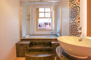 安塔利亚Stunning Studio Flat with Jacuzzi near Hadrian's Gate的浴室配有水槽、淋浴和浴缸。