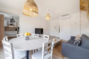 多吕多勒龙L'Hirondelle Verte - Charmante maison pour 6 voyageurs的客厅配有白色桌子和蓝色沙发