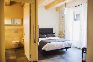 贝萨卢El Call LEstudi en la judería de Besalú的一间卧室配有一张特大号床和一个窗户。