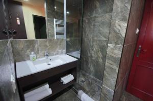 久洛科文酒店的浴室配有白色水槽和淋浴。