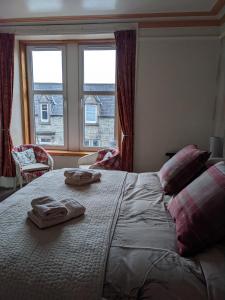 达夫敦Gowanbrae Bed and Breakfast的一间卧室配有一张大床和两条毛巾