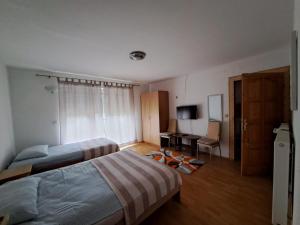 LadimirevciPrivatni smještaj Tolić的一间卧室配有两张床、一张桌子和一台电视。