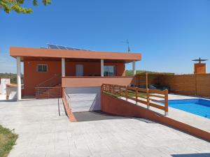 赫罗纳Piscina de sal Barbacoa Wifi, Parking Gratis, 3 min PGA Casa El Roble的一座带游泳池和房子的度假屋