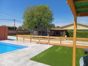 赫罗纳Piscina de sal Barbacoa Wifi, Parking Gratis, 3 min PGA Casa El Roble的游泳池旁的木栅栏