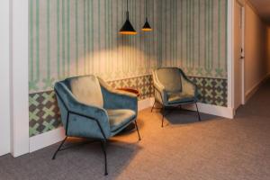 塔拉戈纳劳里亚酒店的两把椅子,房间装饰着绿色和白色的壁纸