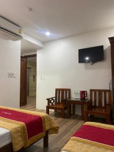 格卢市社Khách sạn An Phú Cửa Lò的酒店客房设有两张床和一台平面电视。