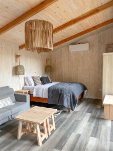 马拉卡韦罗Cabañas Los Huemules的一间卧室配有一张床、一张沙发和一张桌子