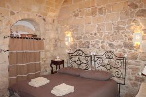阿尔塔穆拉Malta & Tufo的卧室配有一张石墙床