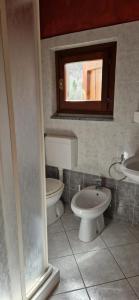Castel FocognanoCasa Carda di Lai Loretta的浴室设有2个卫生间、水槽和窗户。