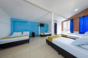 麦德林Hotel Confort Obelisk的一间卧室设有两张床和蓝色的墙壁