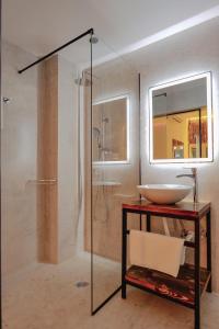 卡萨米尔Hotel Piramida的一间带水槽和玻璃淋浴的浴室