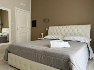 庞贝Pompei via Roma Suite的一张白色的大床,带两条毛巾