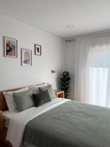 São Pedro de AlvaJasmine Hotel的白色的卧室设有一张大床和一个窗户