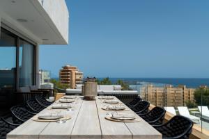 福恩吉罗拉Villa Palm Beach - Incredible villa with 5 rooms, amazing sea view and private pool的建筑屋顶上的一张长木桌