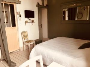 布雷里奥海滨A La Dolce Vita的一间卧室配有一张床、一把椅子和镜子