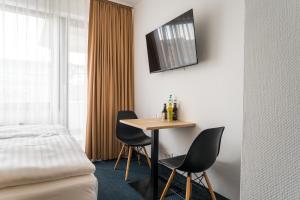 杜塞尔多夫Apartments an der Kö的酒店客房配有一张桌子和两把椅子