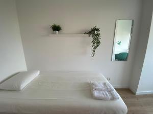 奥埃拉斯Carcavelos Beach walking distance room in shared apartment的白色的卧室配有白色的床和镜子