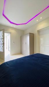 利雅德شاليه الماسيه خاص و مميز بأحدث المواصفات لنصنع الجمال بعينه的一间卧室配有一张紫色天花板的床