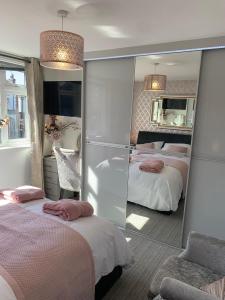 乔利Kensington Luxury Apartment on Gated Development in Leafy edge of Chorley Town Centre的酒店客房,设有两张床和镜子
