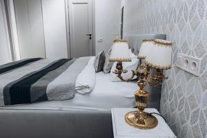 敖德萨Esther House Hotel Museum的一间卧室配有一张带两张台灯的床。