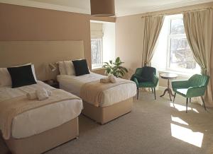 达夫敦Abbeyfield B&B的酒店客房带两张床和一张桌子以及椅子。