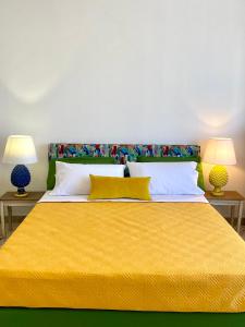 巴勒莫Casa Graziusa的一间卧室配有一张带两盏灯的大型黄色床。