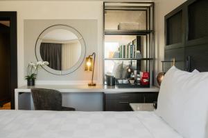 格林维尔Hotel Hartness的一间卧室配有一张床、镜子和一张书桌
