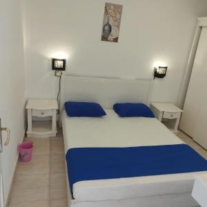 沙姆沙伊赫Juliee House-Criss Resort-Naama Bay的一间卧室配有白色和蓝色的床和两张桌子
