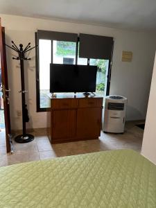 蒙得维的亚Linda casa en Barra de Carrasco的卧室配有梳妆台上的平面电视