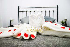 隆达ALOJAMIENTO ARAHAL - RONDA的一张带白色毯子和枕头的床