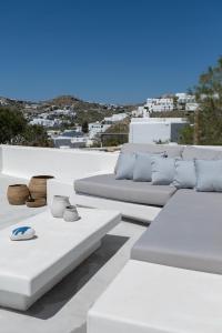 普拉迪斯亚罗斯myMykonos Guest House的屋顶上带白色沙发的白色庭院