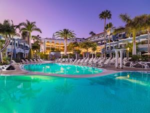 阿德耶阿德里安科隆瓜纳哈尼成人酒店的酒店前方的大型游泳池配有椅子和棕榈树
