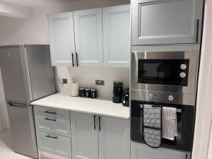 科尔切斯特ED Colchester House的厨房配有白色橱柜和炉灶烤箱。